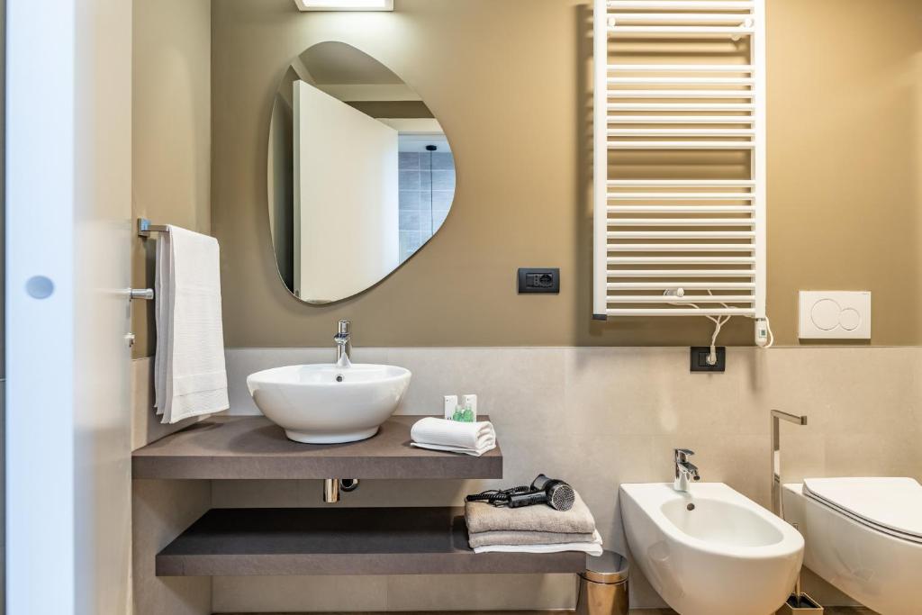 a bathroom with a sink and a mirror at The Place - Only Self Check-in - No Reception in Trento