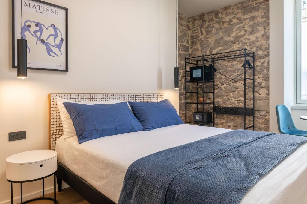 a bedroom with a bed and a blue chair at The Place - Only Self Check-in - No Reception in Trento