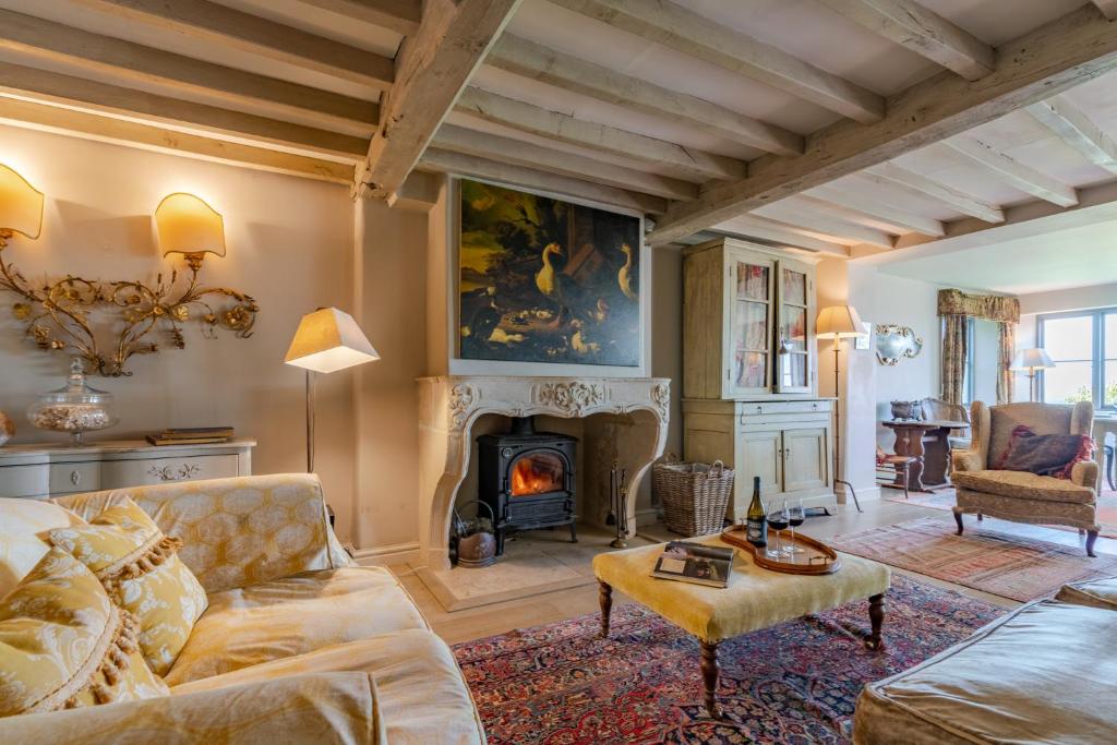 a living room with a couch and a fireplace at Sixpenny Cottage 