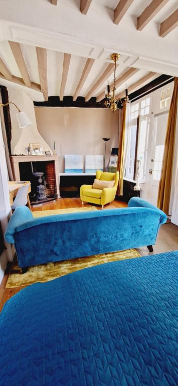 a living room with a blue couch and a fireplace at Chambre d'hôtes Abbatiale in Bernay