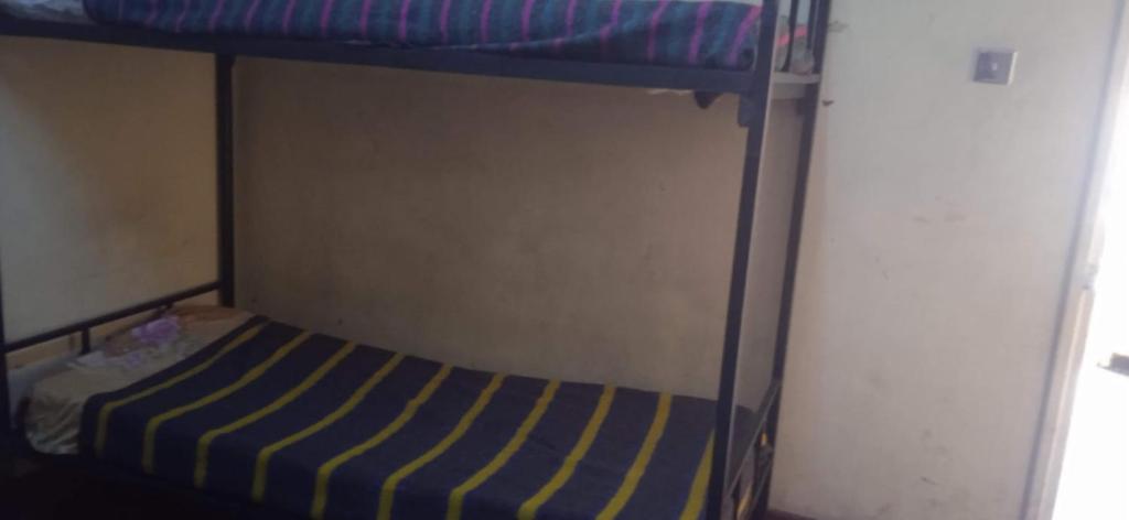 a bunk bed with a blue and yellow striped mattress at Kioneki hostels in Nairobi