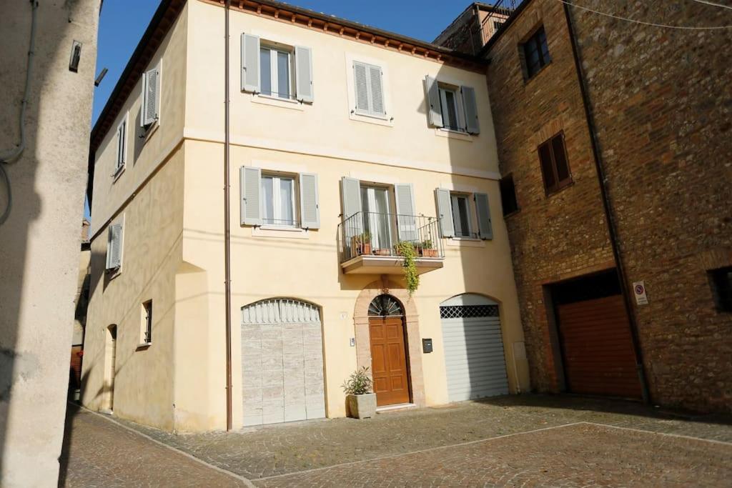 duży biały budynek z drzwiami i balkonem w obiekcie La Casa nel Borgo w mieście Montecastrilli