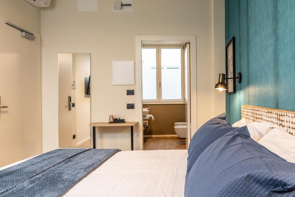 a bedroom with a bed with a blue wall at The Place - Only Self Check-in - No Reception in Trento