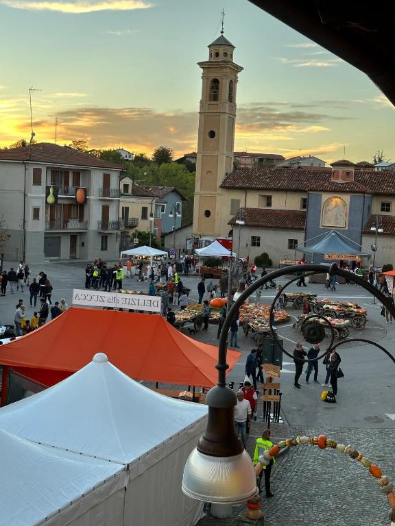 a market in a town with a clock tower at La tana di Piozzo in Piozzo