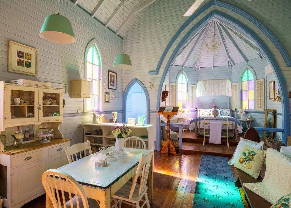 a kitchen and living room with a table in a room at St Aidan's - Converted Church in Mudgee