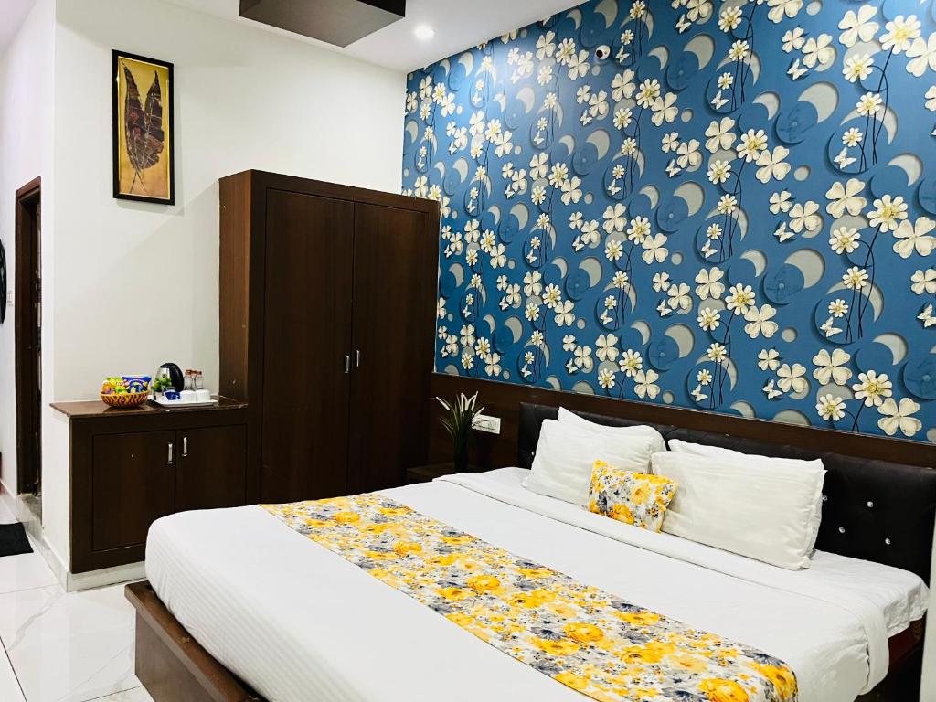 a bedroom with a bed with a blue wall at Hotel Plaza Airport Zone in Shamshabad