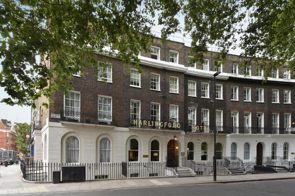 un grand bâtiment en briques avec un panneau. dans l'établissement Harlingford Hotel, à Londres