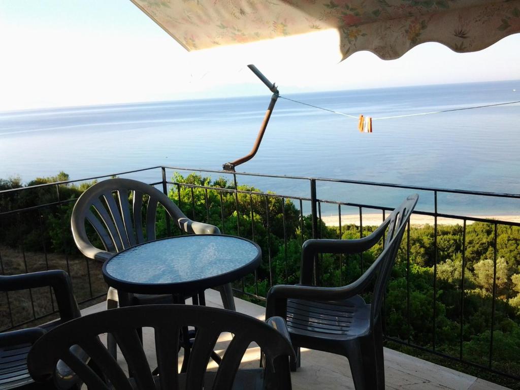 a table and chairs on a balcony with a view of the ocean at Athanasios Tsoumas Apartments in Kastrosikia