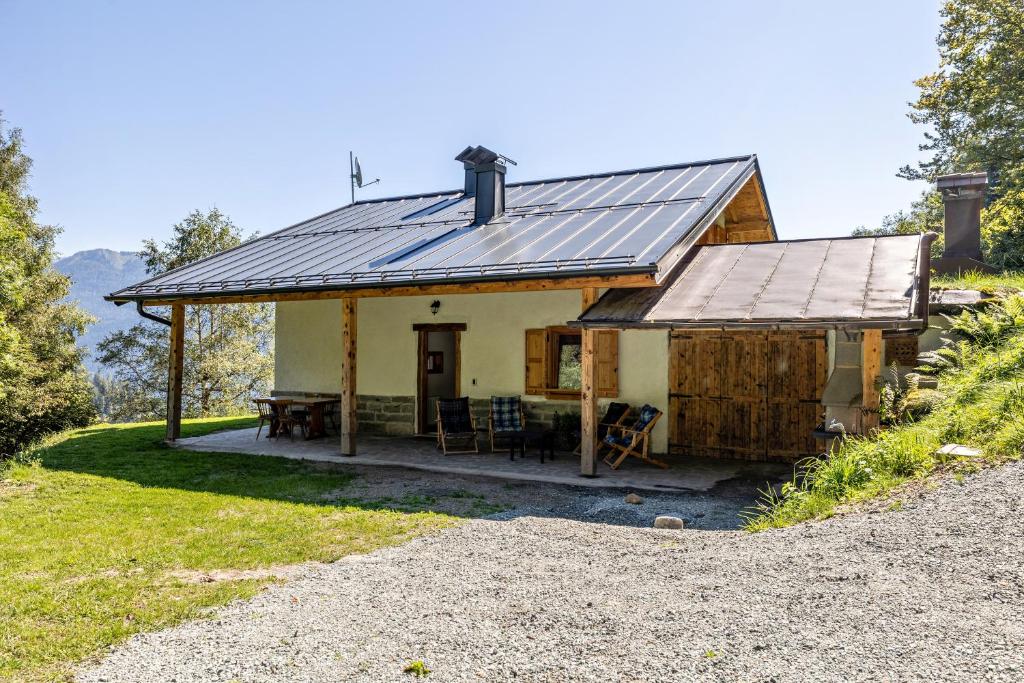 una casa con techo de metal y mesa de picnic en Baita Cisina, 