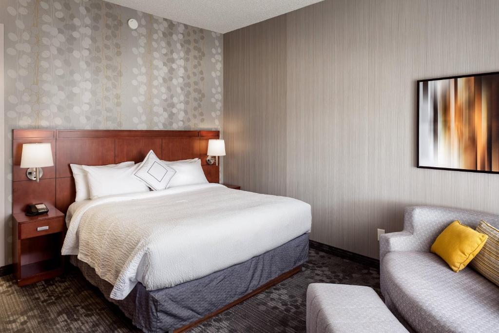 A bed or beds in a room at Courtyard by Marriott Stockton