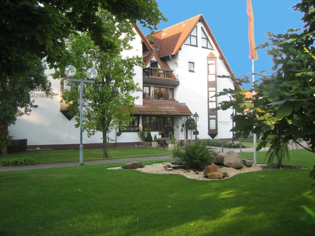 un gran edificio blanco con un patio con césped verde en Ferienwohnungen Deidesheim en Deidesheim