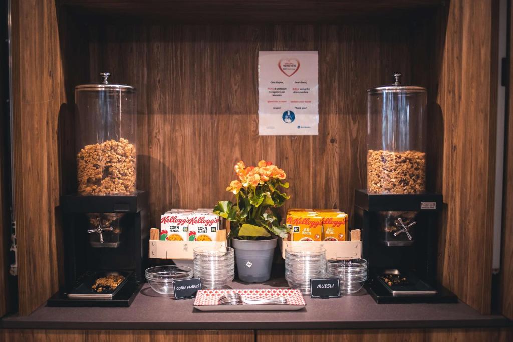 a shelf with three containers of food and other foods at Best Western Mirage Hotel Fiera in Paderno Dugnano