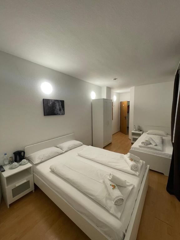 a bedroom with two beds with white sheets at Hotel Starlight in Frankfurt