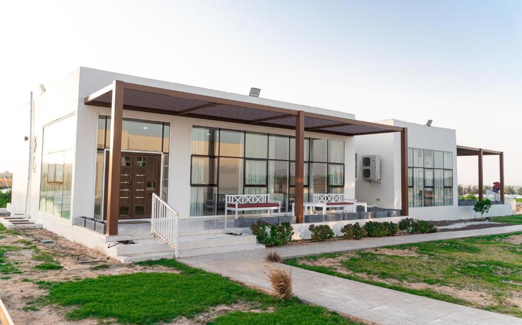 a building with two benches in front of it at مزرعة واستراحة الفقع in Al Faq‘