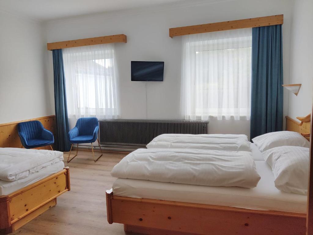 a bedroom with two beds and a tv and two chairs at Neuhof in Neuhofen an der Ybbs