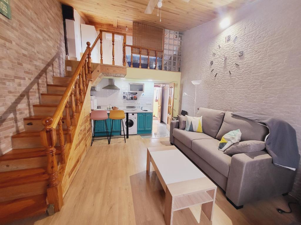 a living room with a couch and a staircase at Apartamento Santa Agueda in Burgos