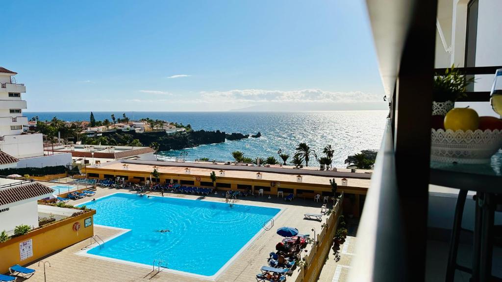 プエルト・デ・サンティアゴにあるSeguro El Sol 411のスイミングプールと海の景色を望めます。