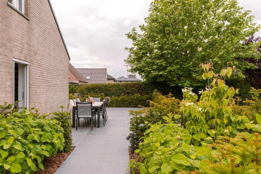 a patio with a table and chairs in a garden at Villa Bakboord in Ostend