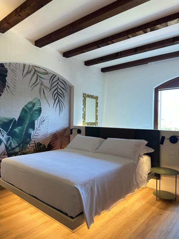 a bedroom with a large white bed and a window at Locanda Arizona in Bardolino