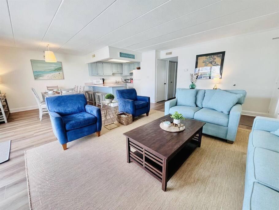 a living room with blue chairs and a table at Beach Front Condo with Spectacular Views in Ocean City