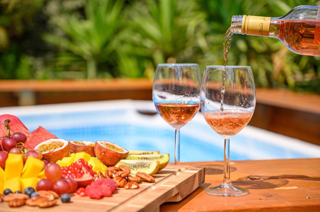 two glasses of wine next to a tray of food at העוגן והים - The Anchor and the Sea in Shlomi
