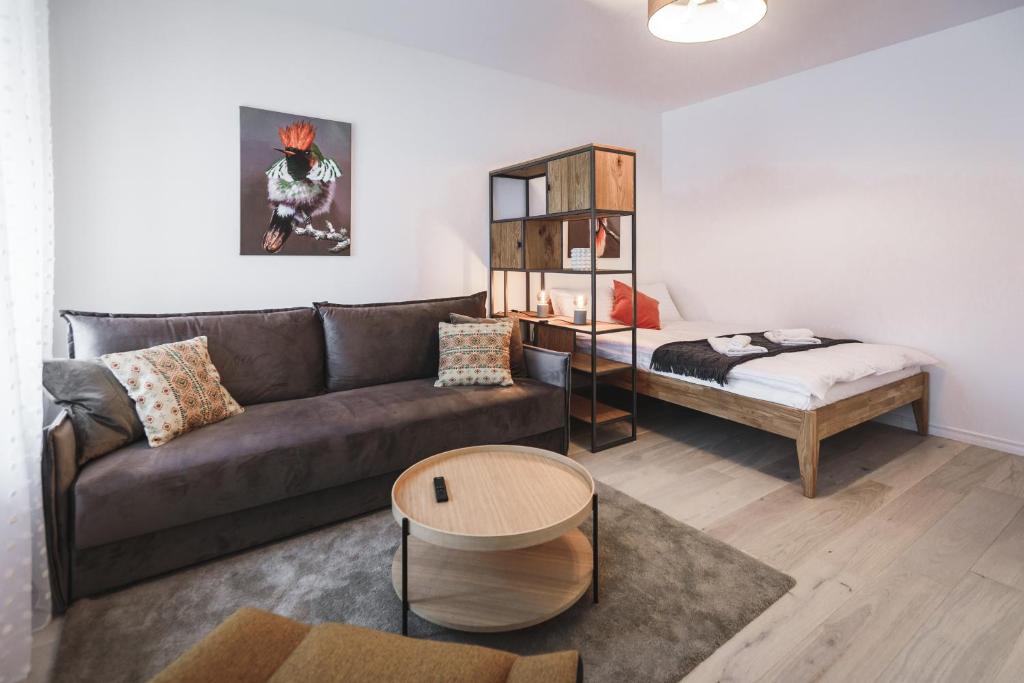 Bearsleys Knights Apartments في ريغا: غرفة معيشة مع أريكة وطاولة