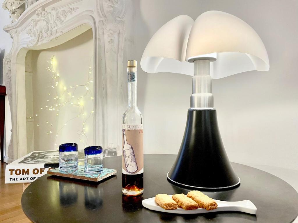 uma garrafa de vinho e um candeeiro sobre uma mesa em La Casa Del Pesce - Within the Historical Walls of Lucca em Lucca