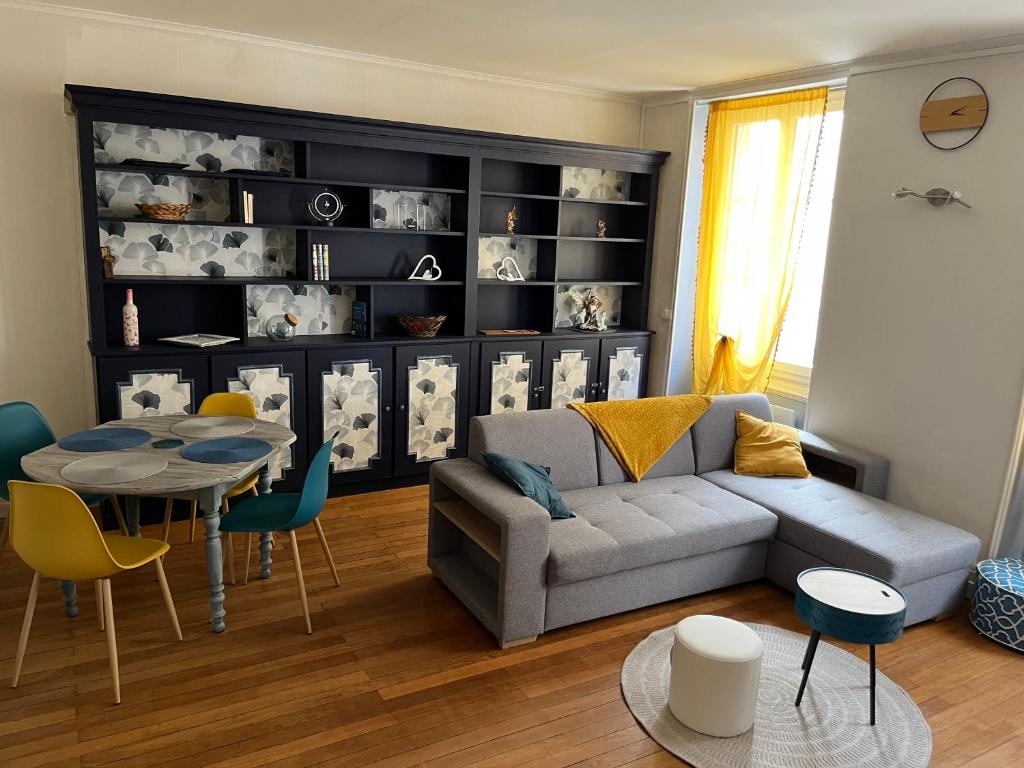 een woonkamer met een bank en een tafel bij Les Avatars in Saint-Amand-Montrond
