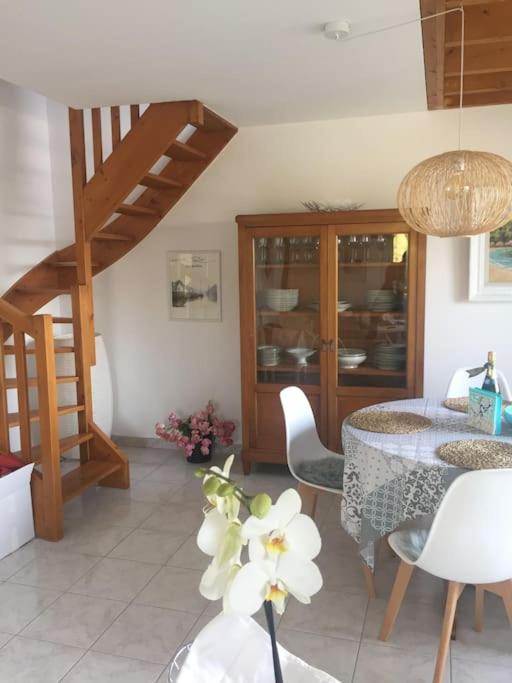 a living room with a table and chairs and a staircase at Plage de rêve et tennis devant la maison in Pornichet