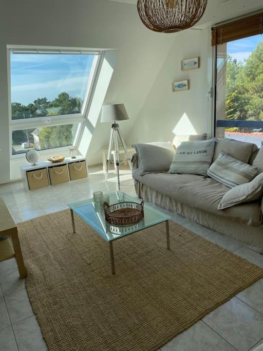 a living room with a couch and a glass table at Plage de rêve et tennis devant la maison in Pornichet
