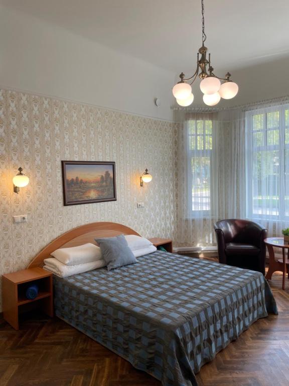 a bedroom with a large bed and a chair at Green Villa in Pärnu