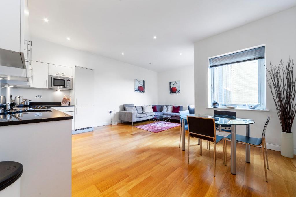 cocina y sala de estar con mesa y sillas en Beautiful 1BDR Apartment near Clapham Common, en Londres