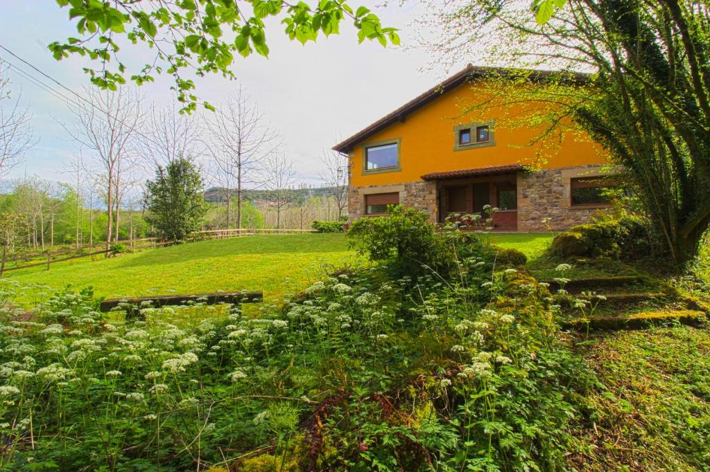 an orange house on a green hill with a yard at La Palombrera in Treceño