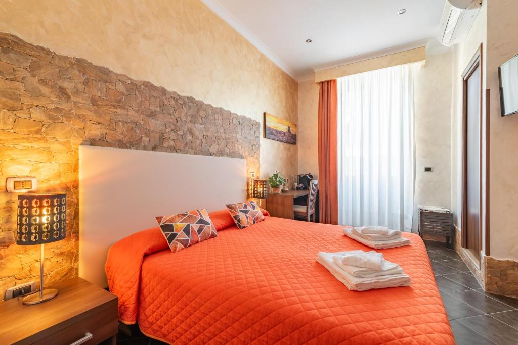 ein Schlafzimmer mit einem Bett mit einer orangefarbenen Tagesdecke in der Unterkunft Alis Laura in Rom