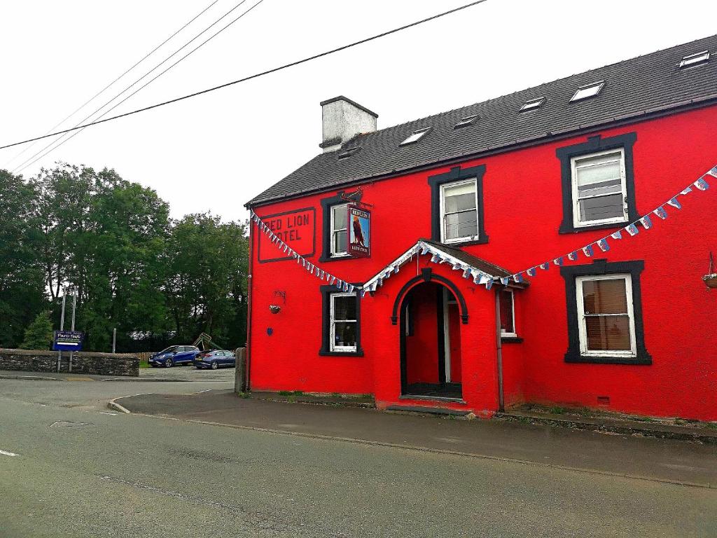 a red house with garland on the side of it at Red Lion Hotel in Ystrad Meurig
