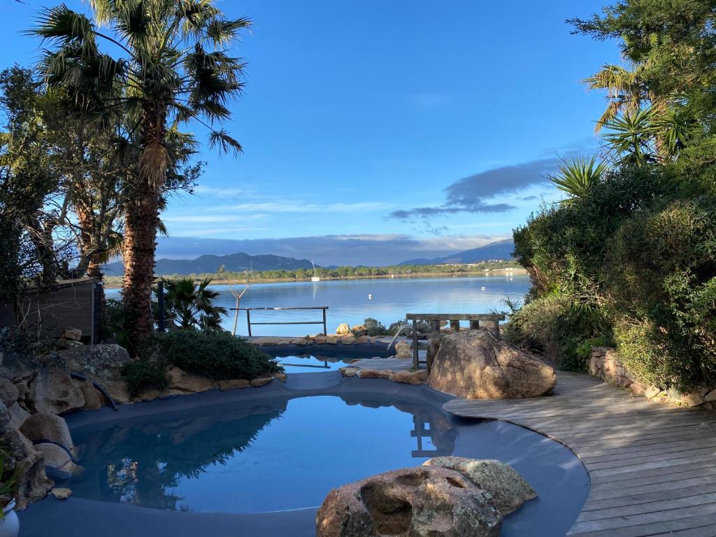 une piscine avec vue sur un plan d'eau dans l'établissement Maranatha, Location de Villas pieds dans l'eau, à Porto-Vecchio