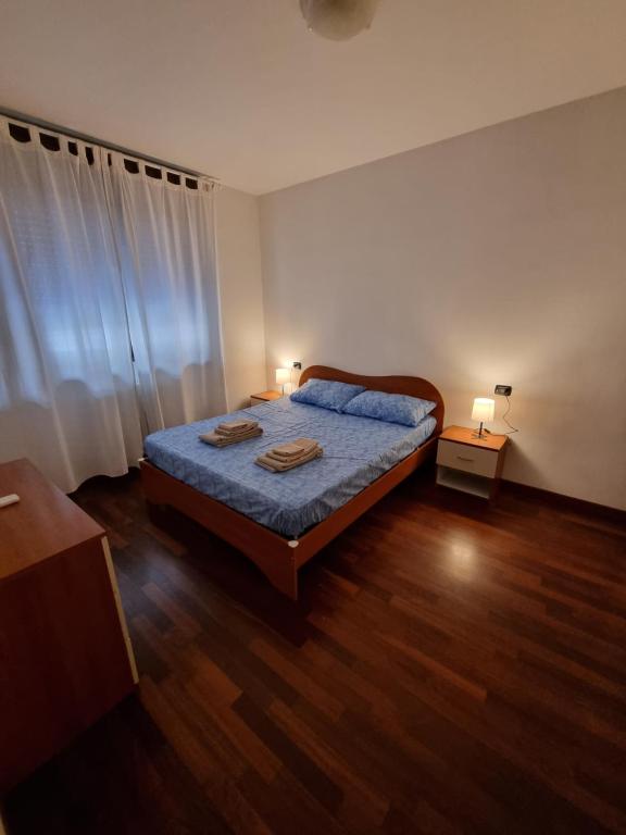 Schlafzimmer mit einem Bett und Holzboden in der Unterkunft Appartamento San Siro Stadio Fiera Milano City Life in Mailand
