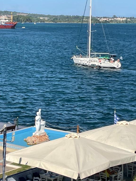 a sail boat in the water with a statue and a boat at ΜΕ ΘΕΑ ΤΗΝ ΓΟΡΓΟΝΑ in Preveza