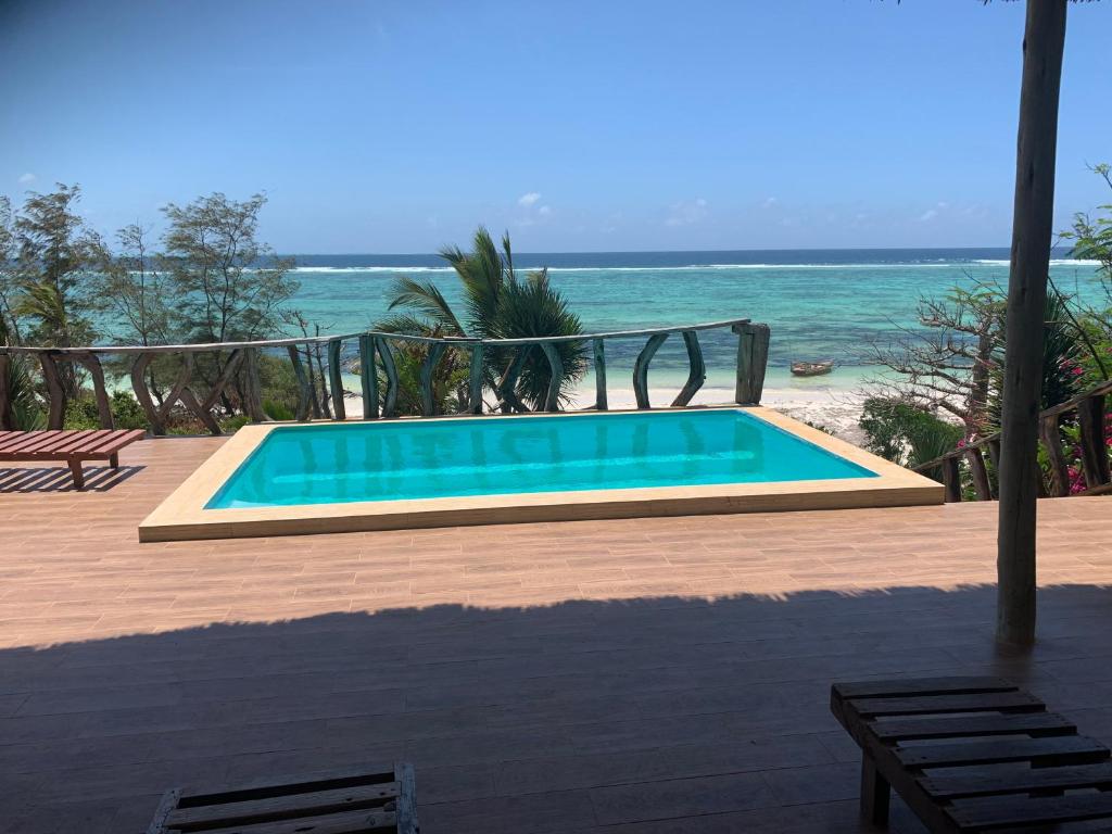una piscina con l'oceano sullo sfondo di Zi Villa Beach Cottage a Matemwe