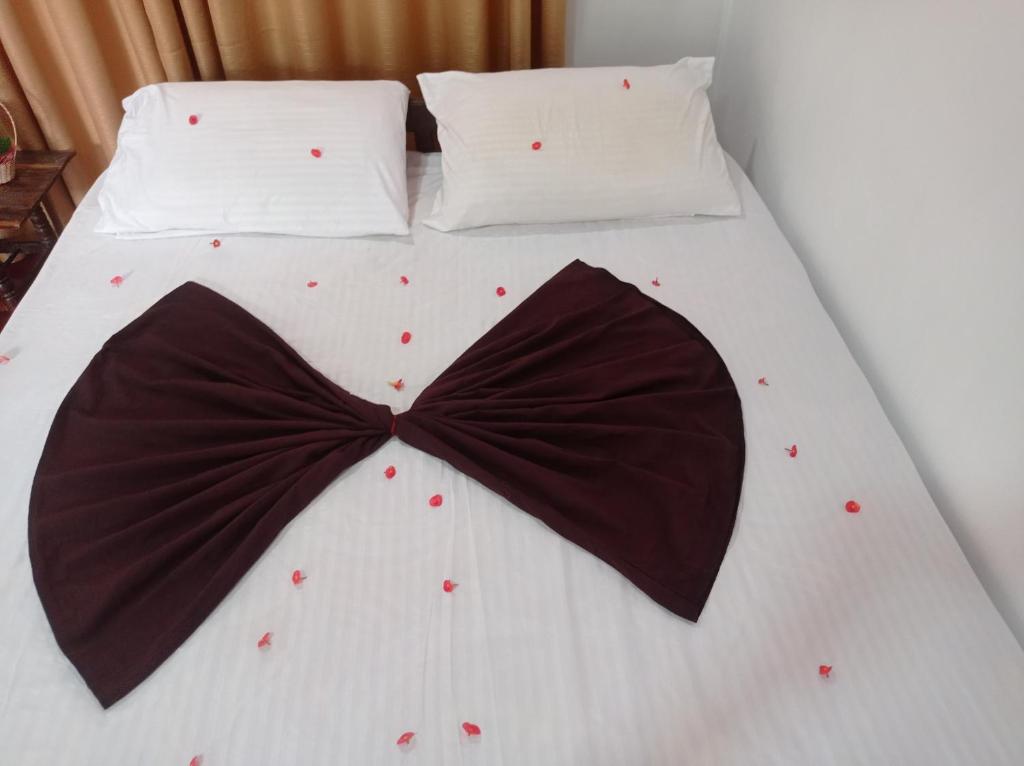 Una cama con una corbata de moño negra. en Weligama Elite Guest, en Weligama