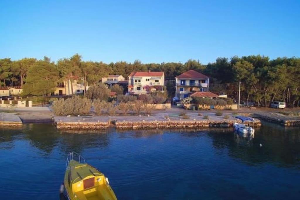 um barco amarelo sentado na água ao lado de um porto em Apartment Dragica (A2), Pašman em Pasman