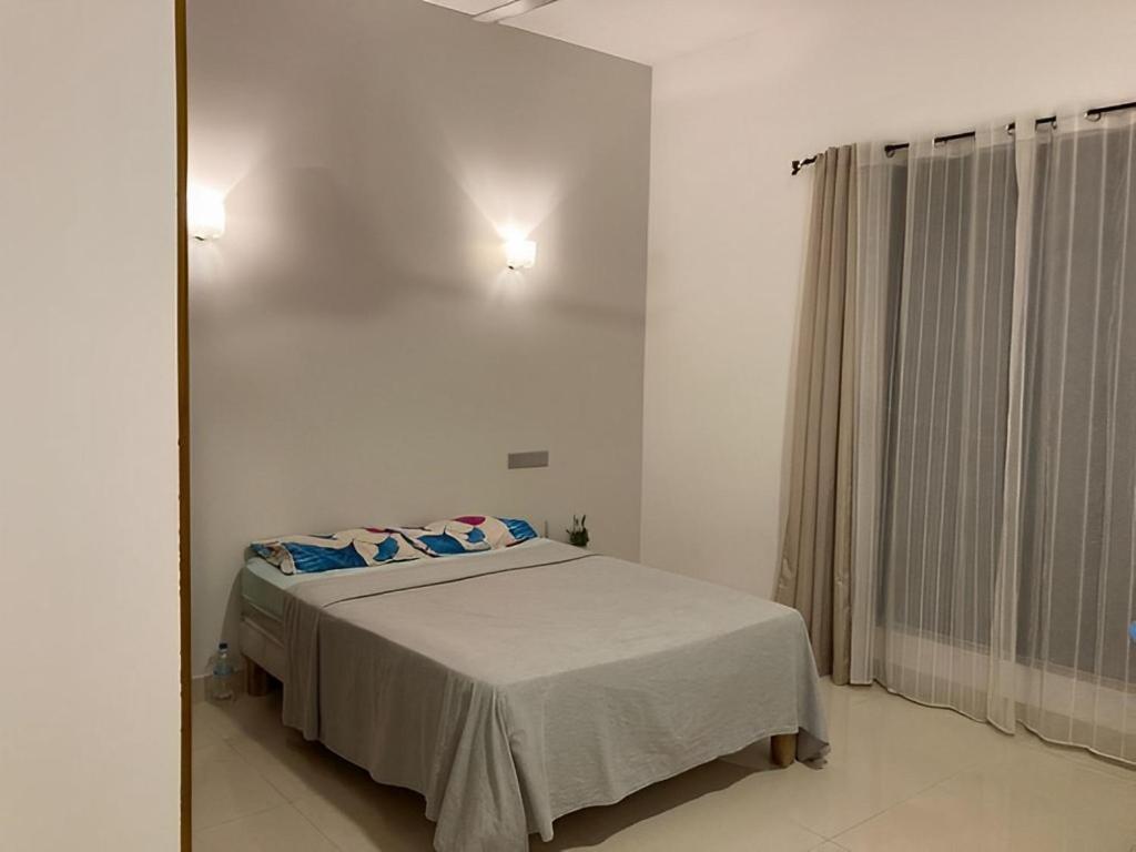 贾埃勒Apartment located 5 minutes from Ja Ela town的带床和镜子的卧室