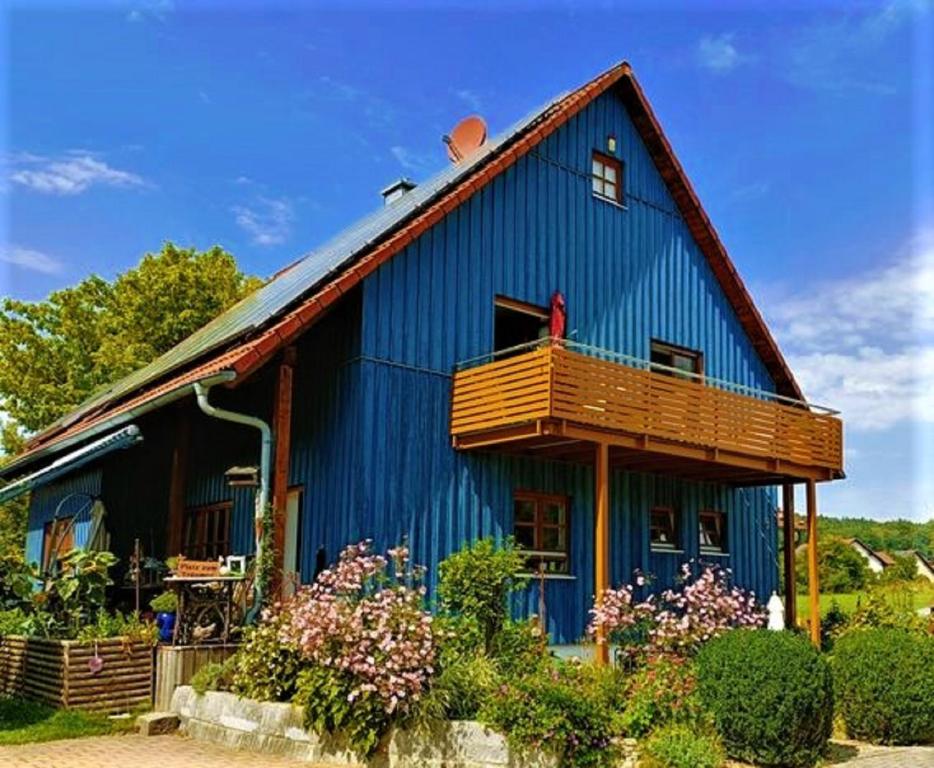 una casa azul con balcón en la parte superior en Ferienwohnung Peuker, en Neukirchen bei Sulzbach-Rosenberg