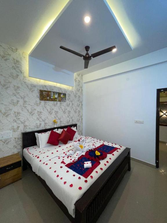 1 dormitorio con 1 cama grande con almohadas rojas en Cofiya Hotel en Madikeri