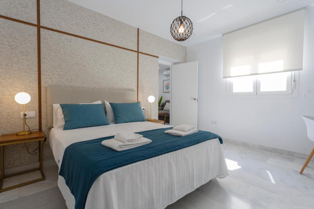 a bedroom with a large bed with blue and white at Apartamentos La BRUJULA by CadizRentals in Cádiz