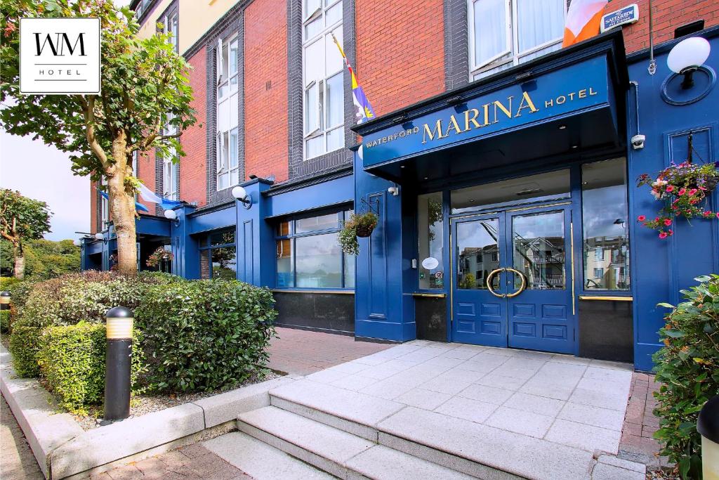 un magasin avec une porte bleue dans une rue dans l'établissement Waterford Marina Hotel, à Waterford