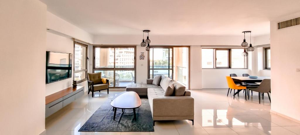 a living room with a couch and a table at Spacious Condo in New North by FeelHome in Tel Aviv