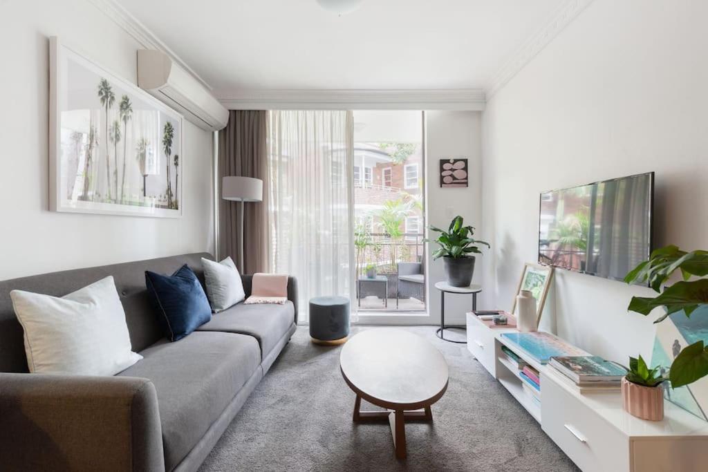 sala de estar con sofá y mesa en Harbourside Style, 2 Bed, A/C, Pool -Elizabeth Bay en Sídney