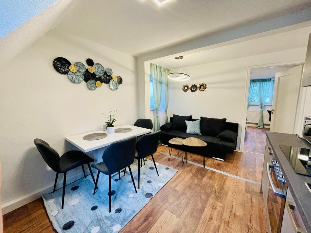 3Rooms Central Modern near MTU- Lakescape FeWos في فريدريشسهافن: غرفة معيشة مع طاولة وكراسي وأريكة