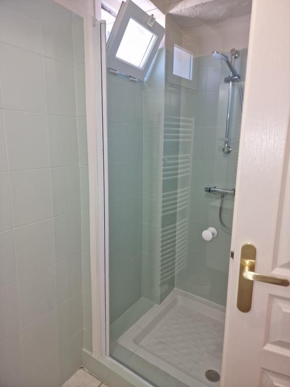 baño con ducha y puerta de cristal en L'émeraude : studio chic et élégant, en Agde